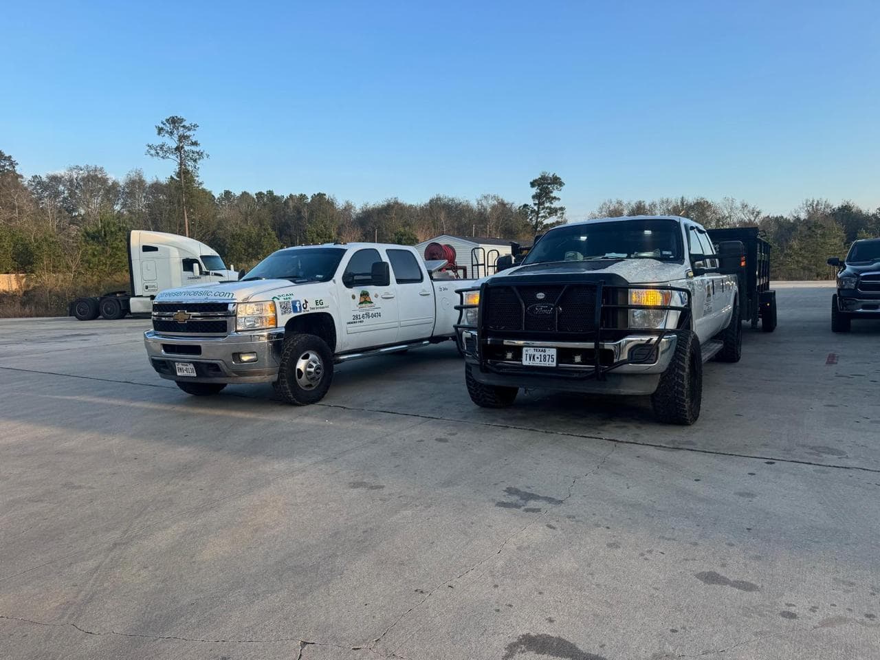 EG Tree Services work trucks and a dump trailer staged at the start of a work day